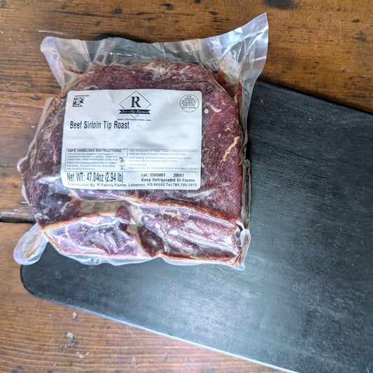 Packaged beef sirloin tip roast with a label on a wooden surface