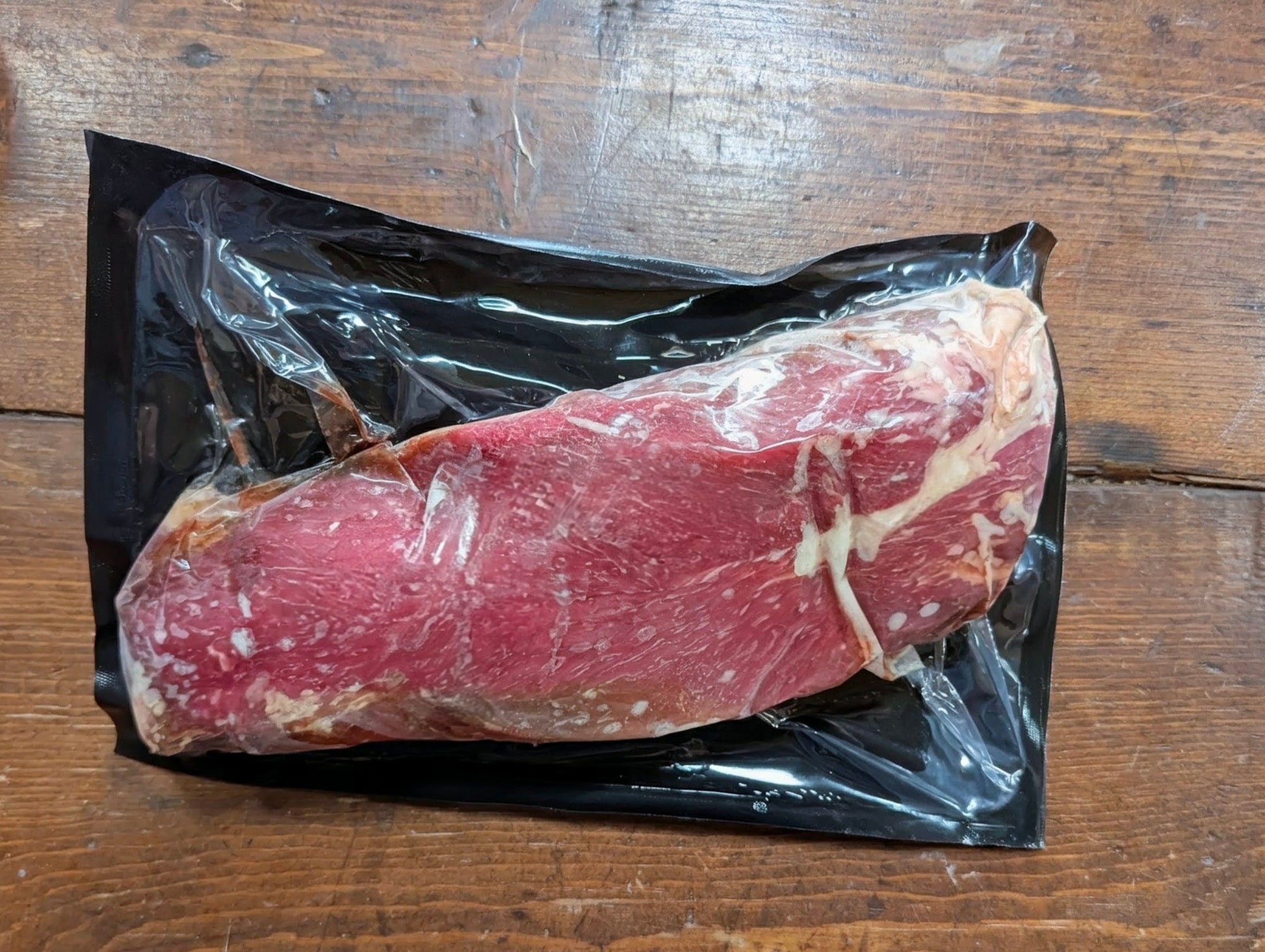 Raw meat package on a wooden surface